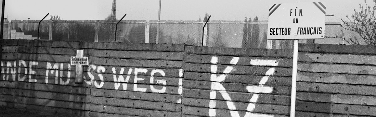 Berlin, ca. 1977 – Gedenkkreuz und Graffito an der Grenzmauer in der Bernauer Straße/Schwedter Straße (Fotograf: Detlef Machmüller)